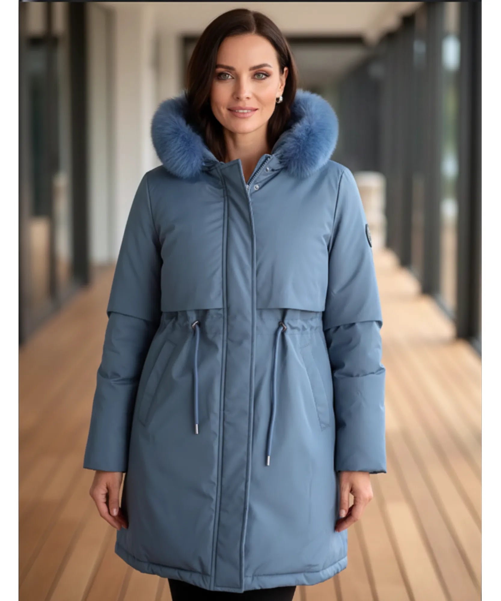 Woman wearing a long parka coat in slate blue