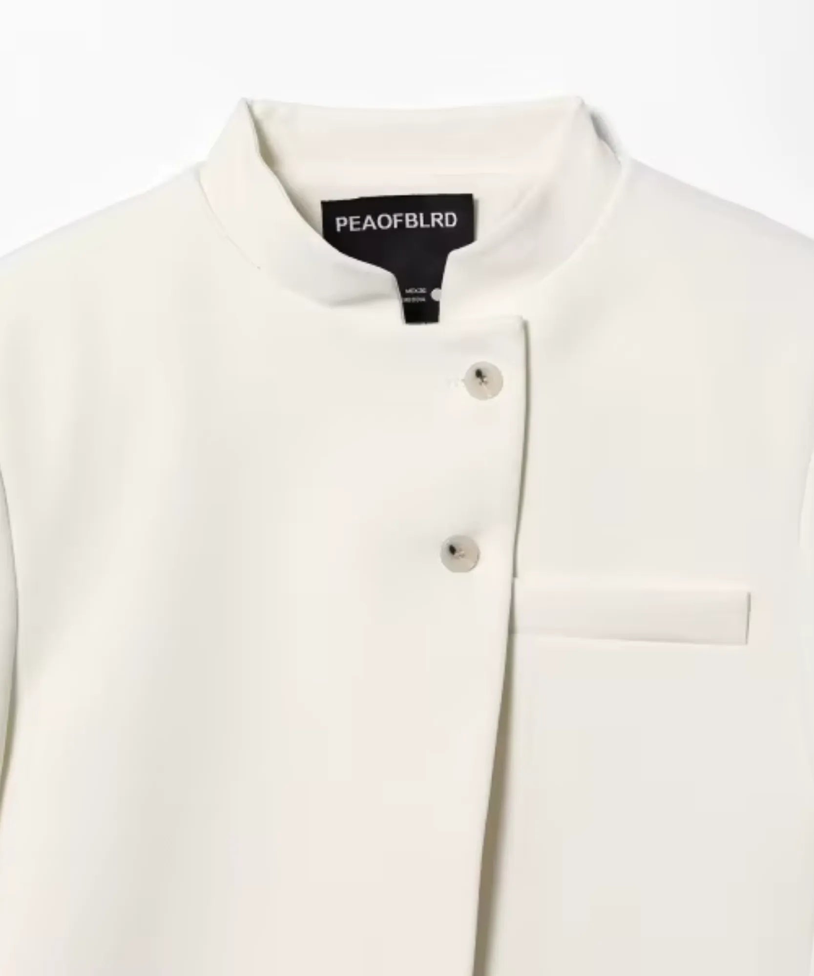 Detail of the mandarin collar, covered buttons and patch pocket on the Ivory blazer