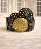 Women's black concho belt with gold buckle worn over a dress
