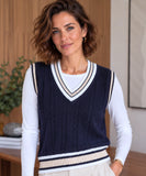 Women's navy cable knit varsity sweater vest worn over a white shirt