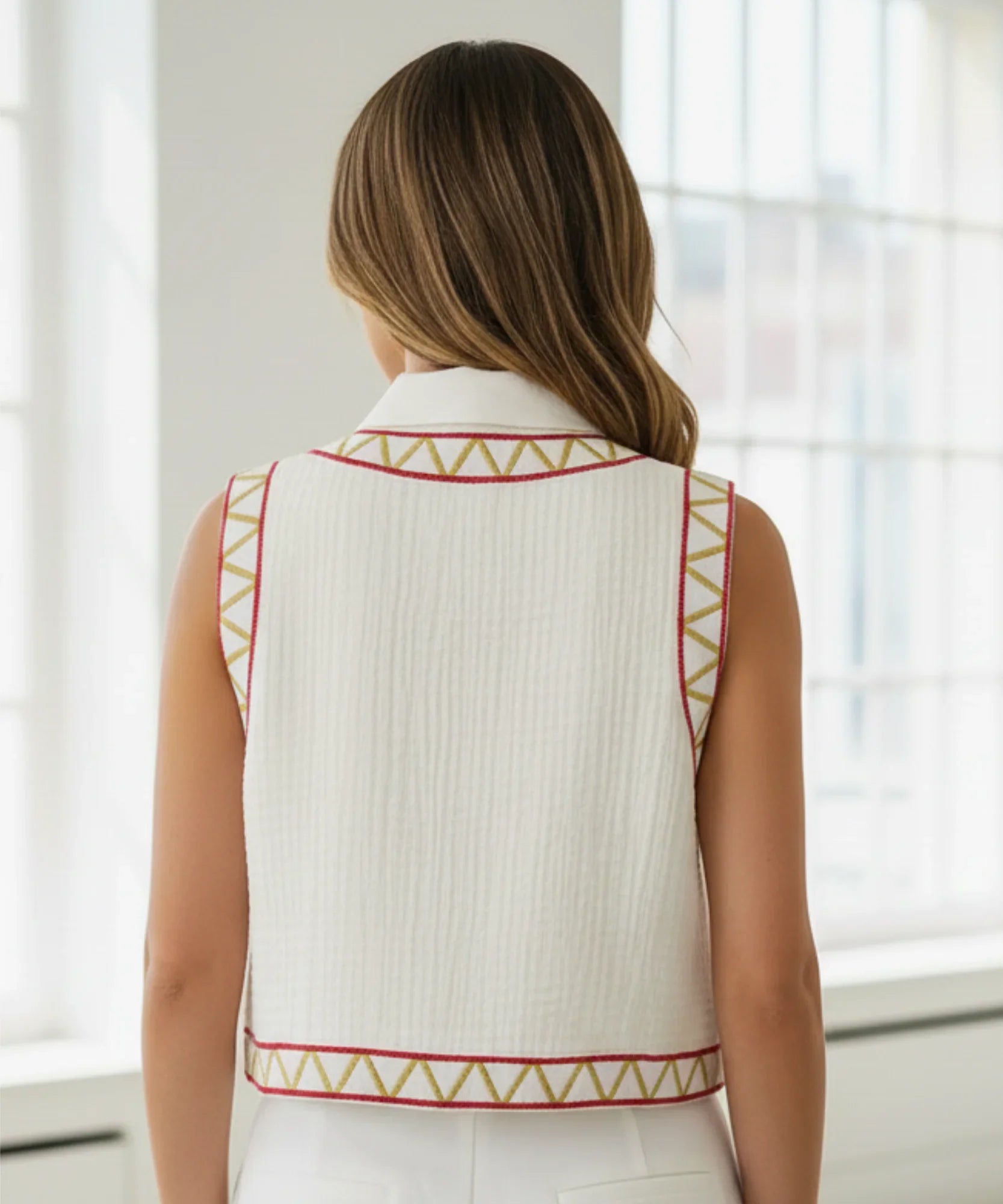 Women's floral embroidered cropped vest in pink, styled with jeans