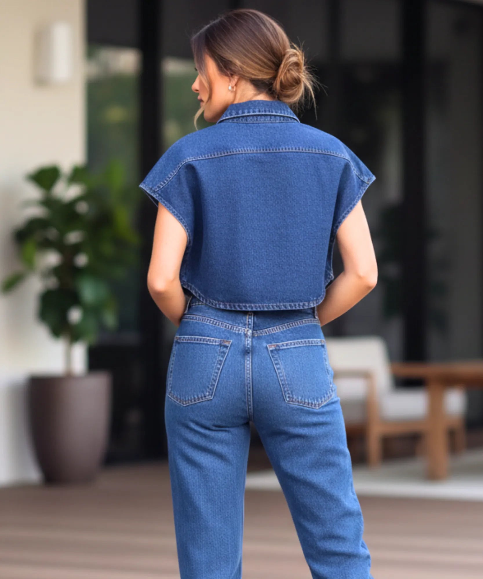 Women's cropped denim vest in blue, close-up of snap-button closure