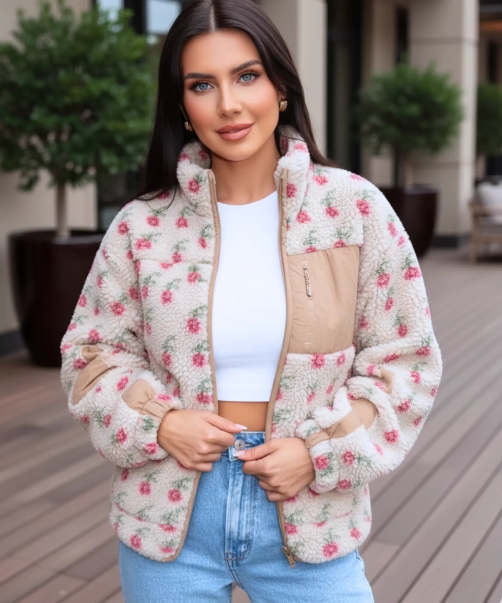 Woman styling the ivory floral fleece jacket outdoors