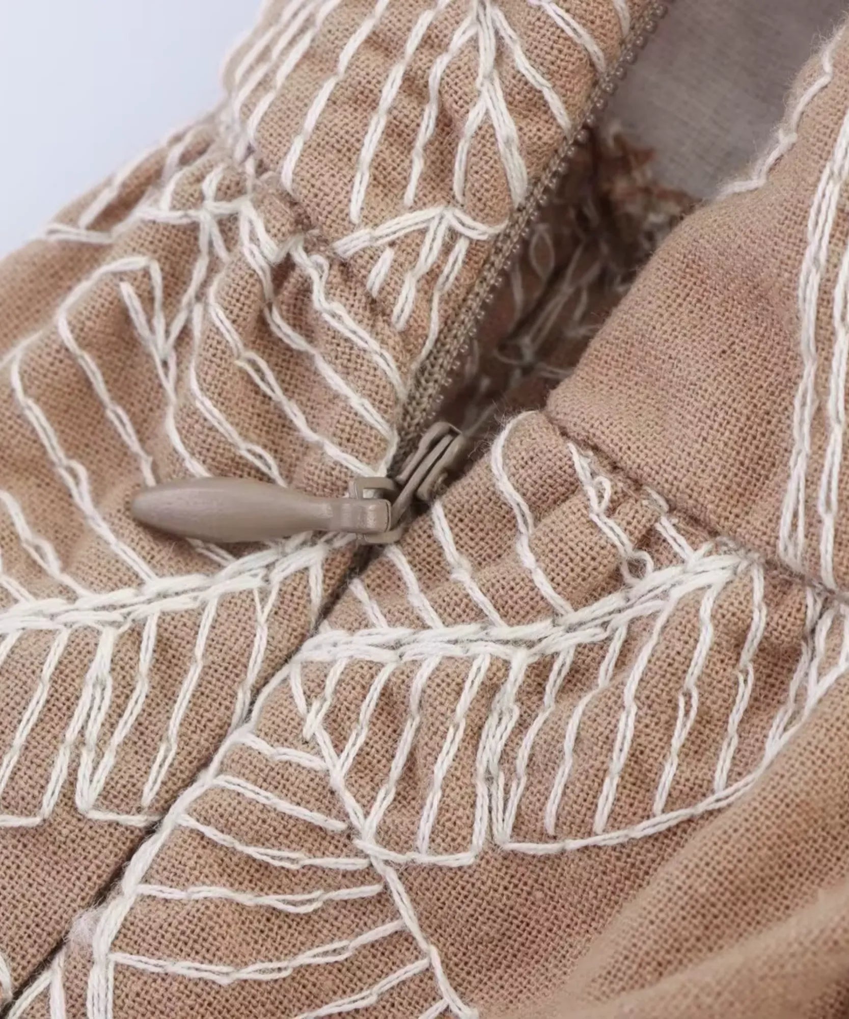 Detail of the side zip on the embroidered wide-leg pants