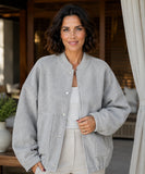 Woman wearing an oversized boucle bomber jacket in grey