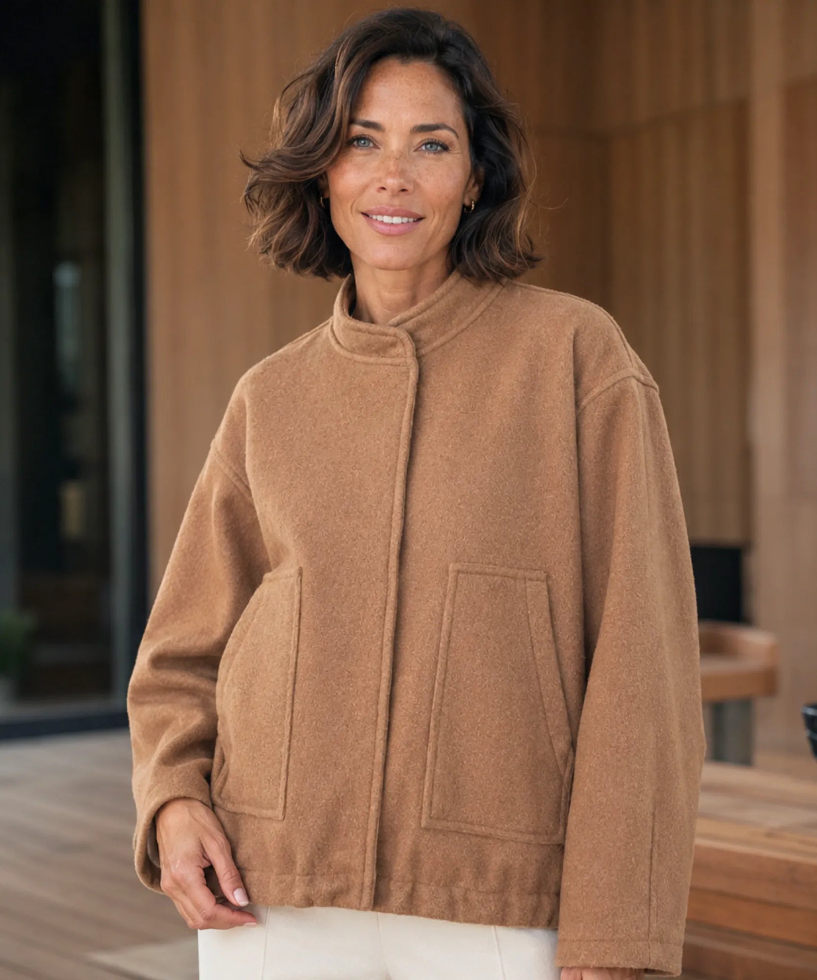 Woman styling the camel boucle bomber jacket outdoors