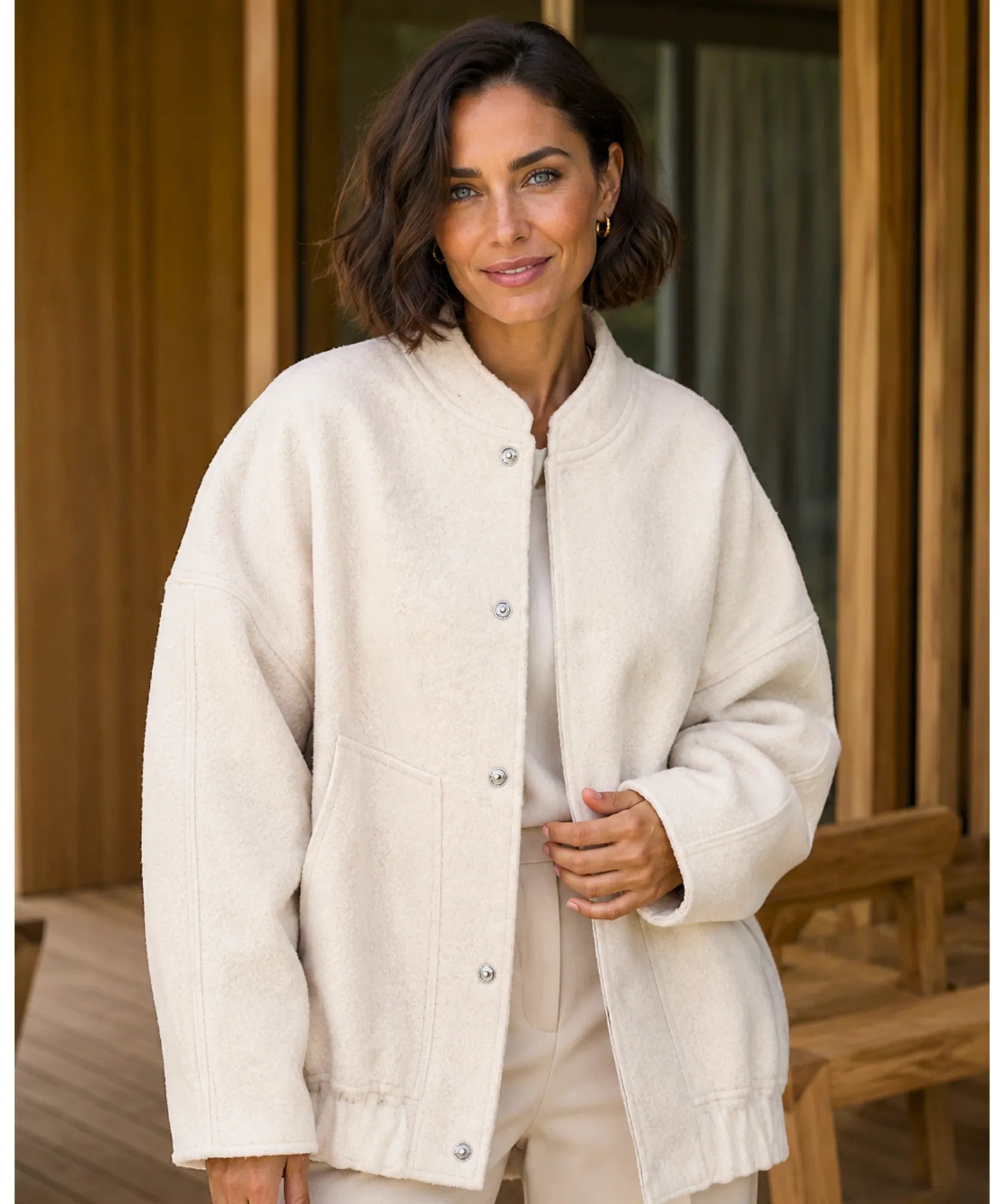 Woman styling the off white boucle bomber jacket outdoors