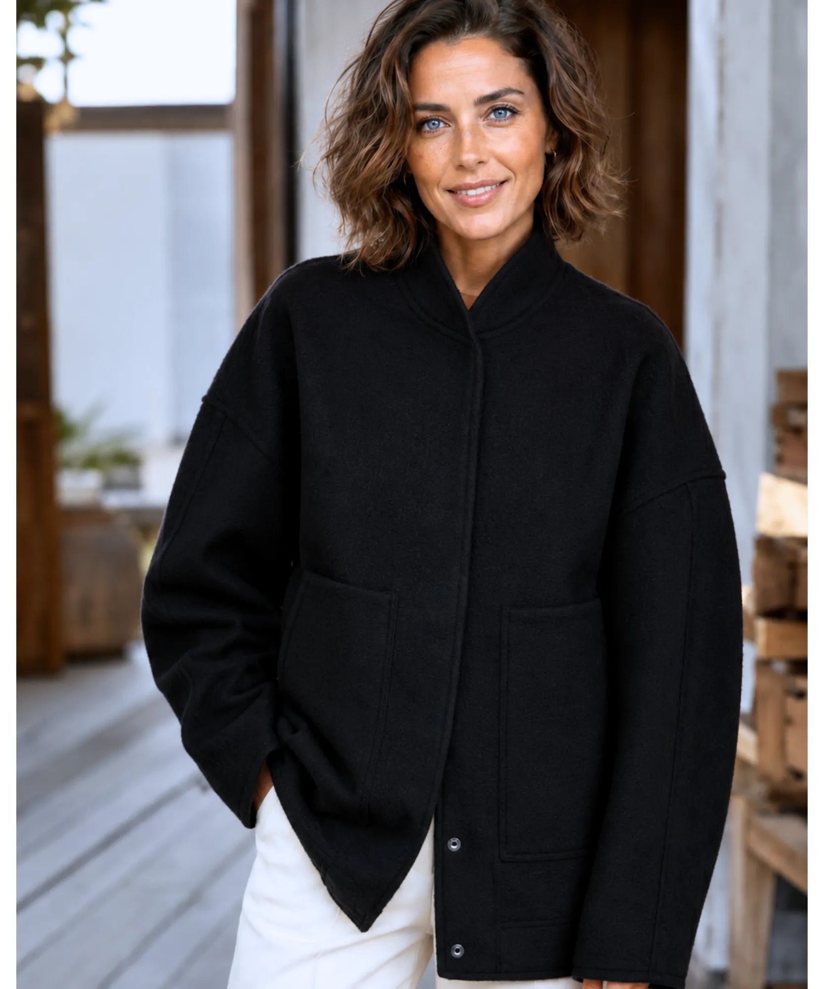 Woman wearing an oversized boucle bomber jacket in black