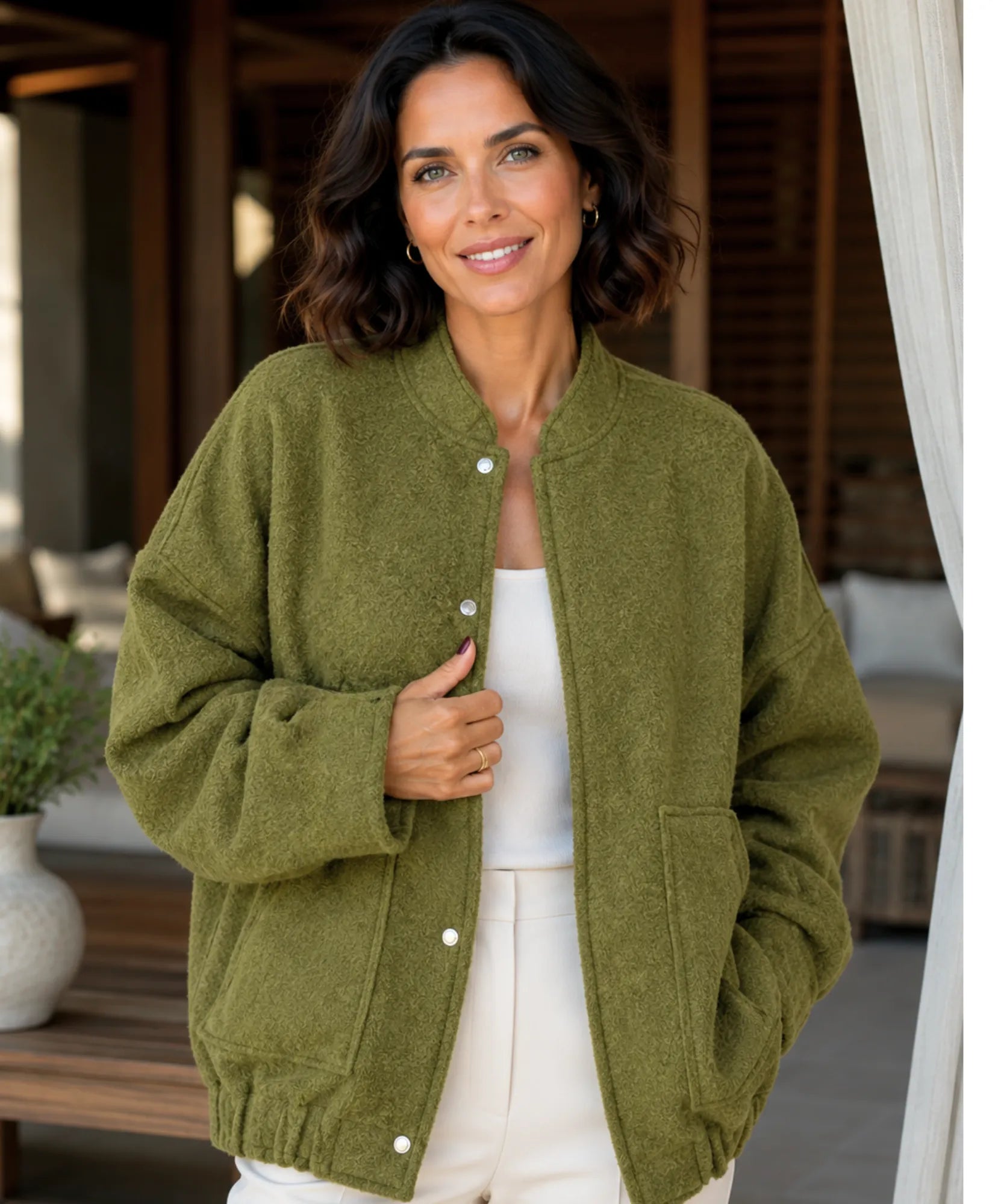 Woman wearing an oversized boucle bomber jacket in olive green