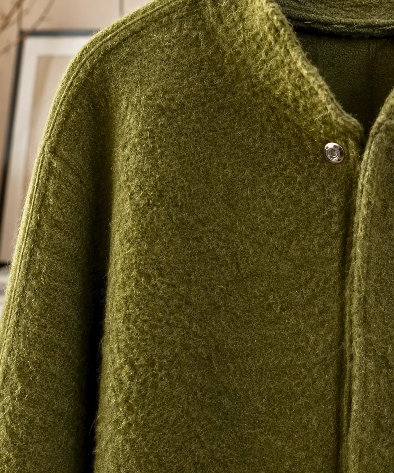 Detail of the collar on the olive green boucle bomber jacket
