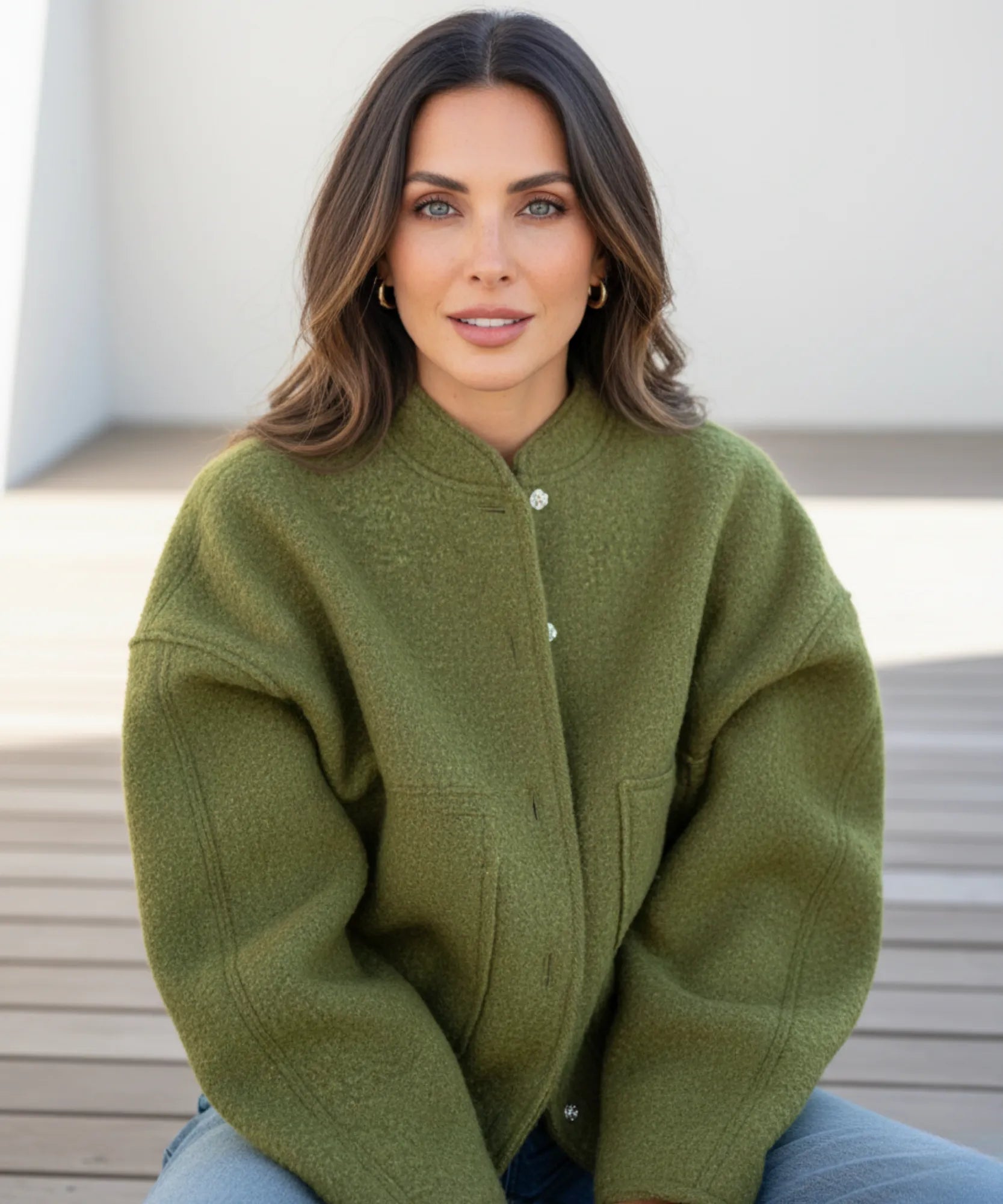 Woman wearing an oversized boucle bomber jacket in olive green