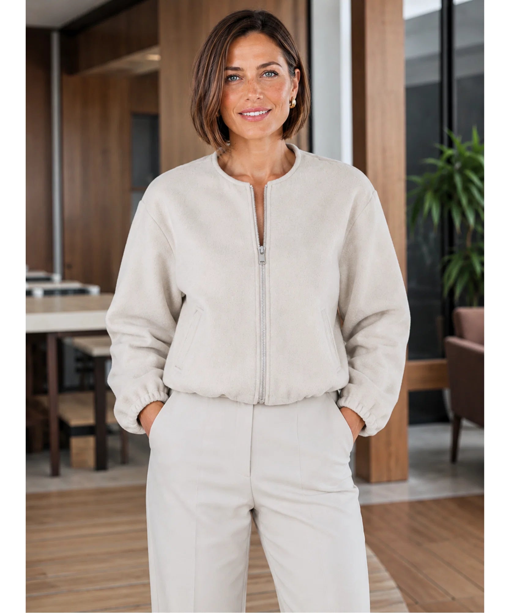 Woman styling the beige wool bomber jacket with jeans