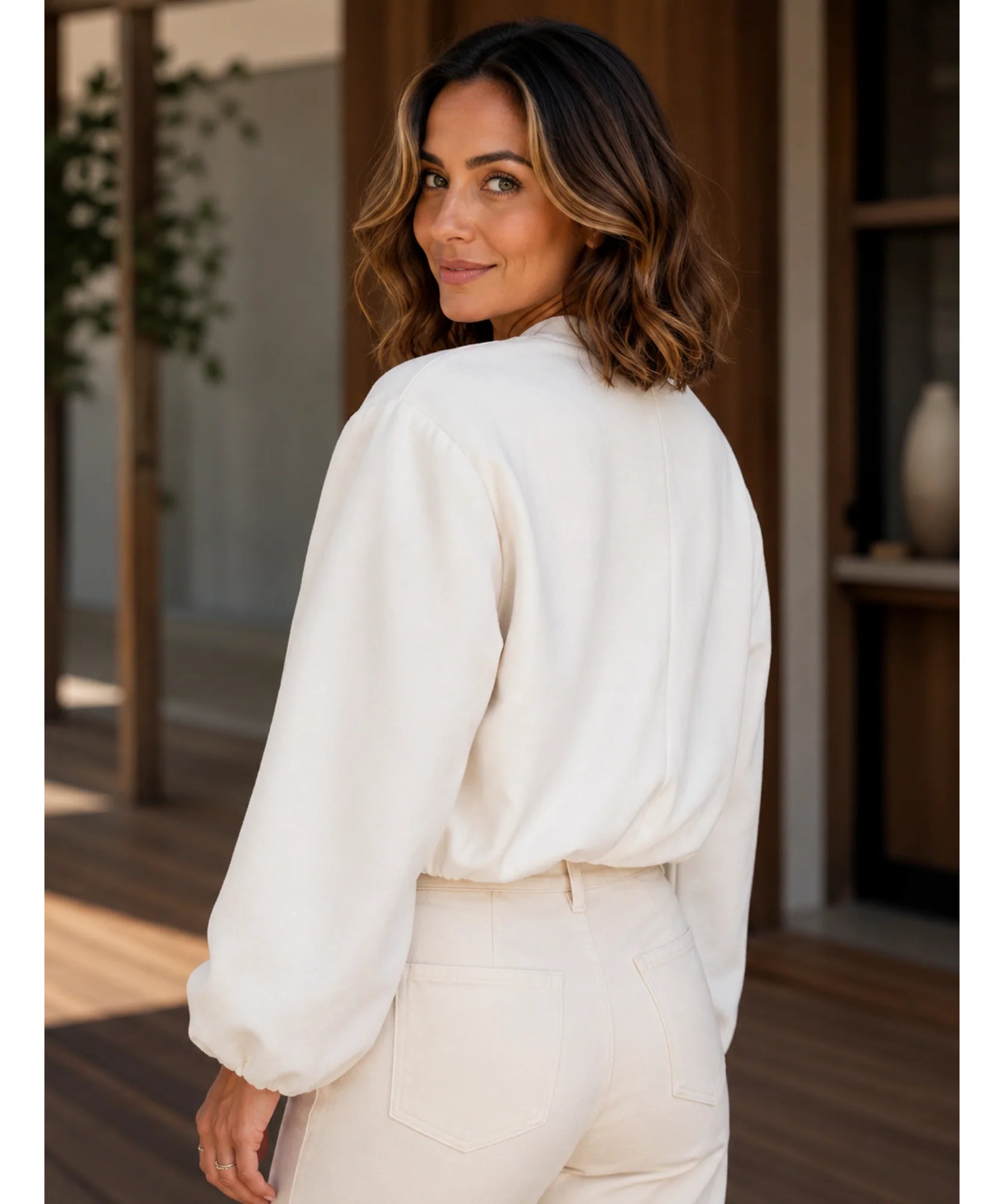 Woman wearing a cropped wool bomber jacket in beige