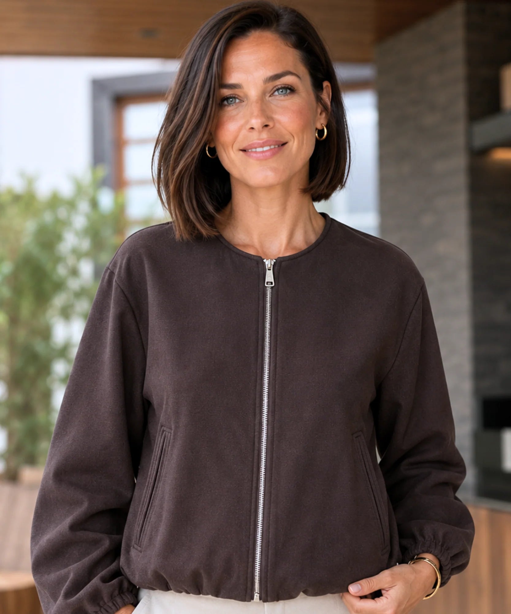Woman wearing a cropped wool bomber jacket in dark brown