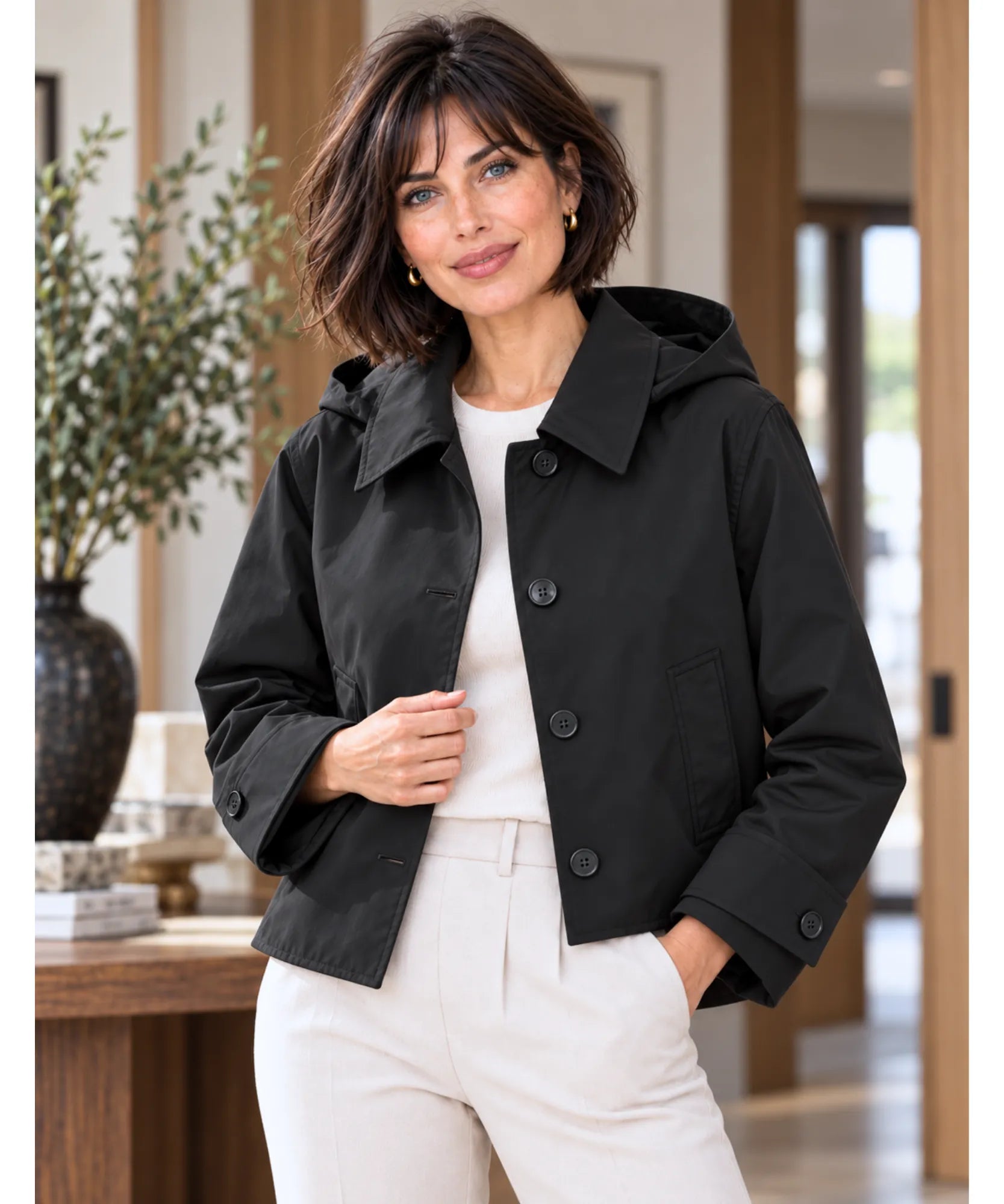 Women's utility jacket in black worn open with white pants
