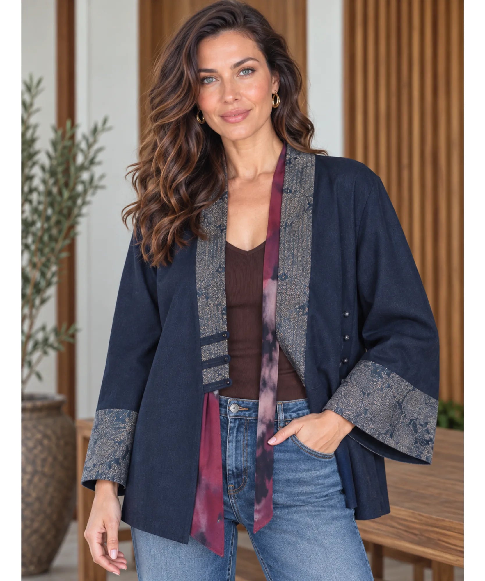 Women's denim kimono jacket worn over a tee with light wash jeans and a scarf