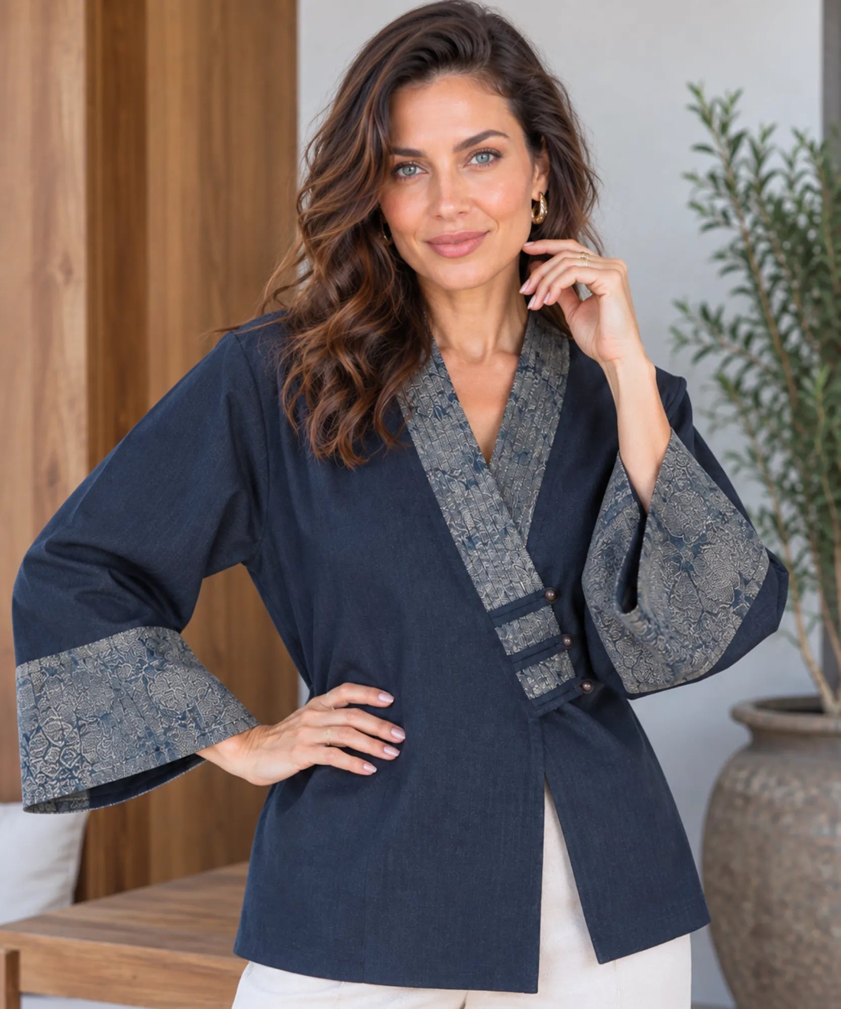 Women's navy denim kimono jacket with wide sleeves and hand on hip