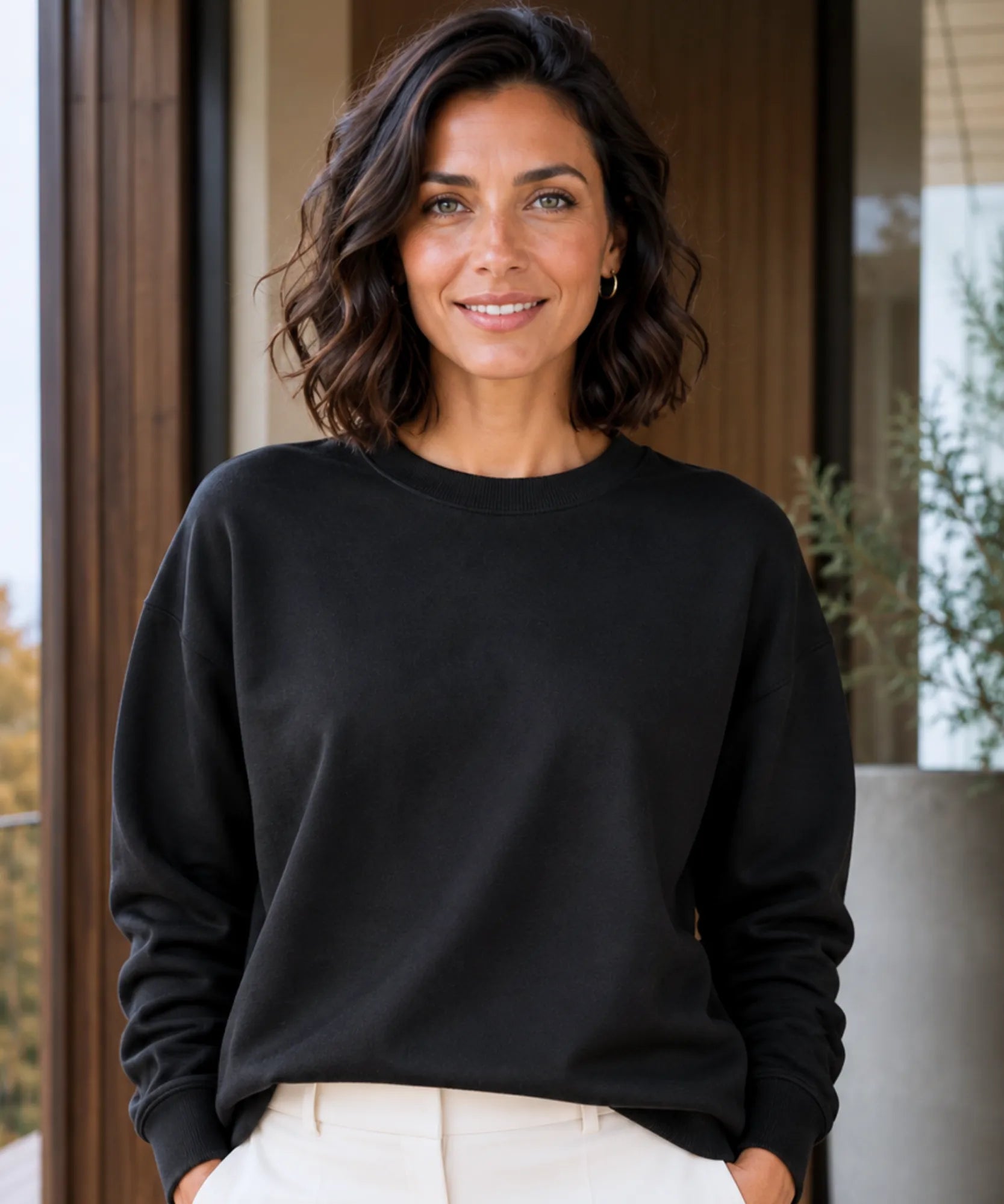 Women's black fleece lined crew neck sweatshirt styled with cream pants