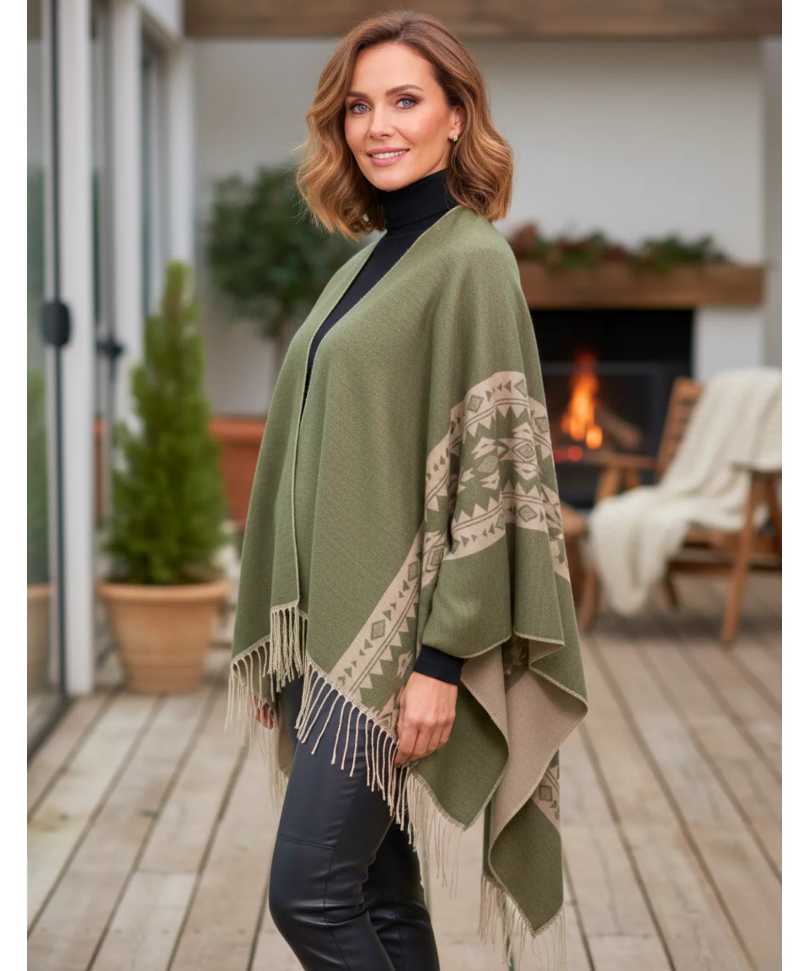 Women's aztec print ruana wrap in sage green with fringe hem, styled indoors