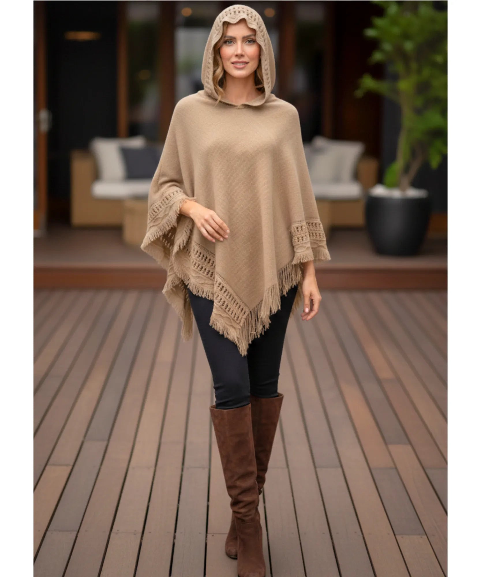 Women's hooded poncho sweater in camel chunky knit, styled with leggings and boots
