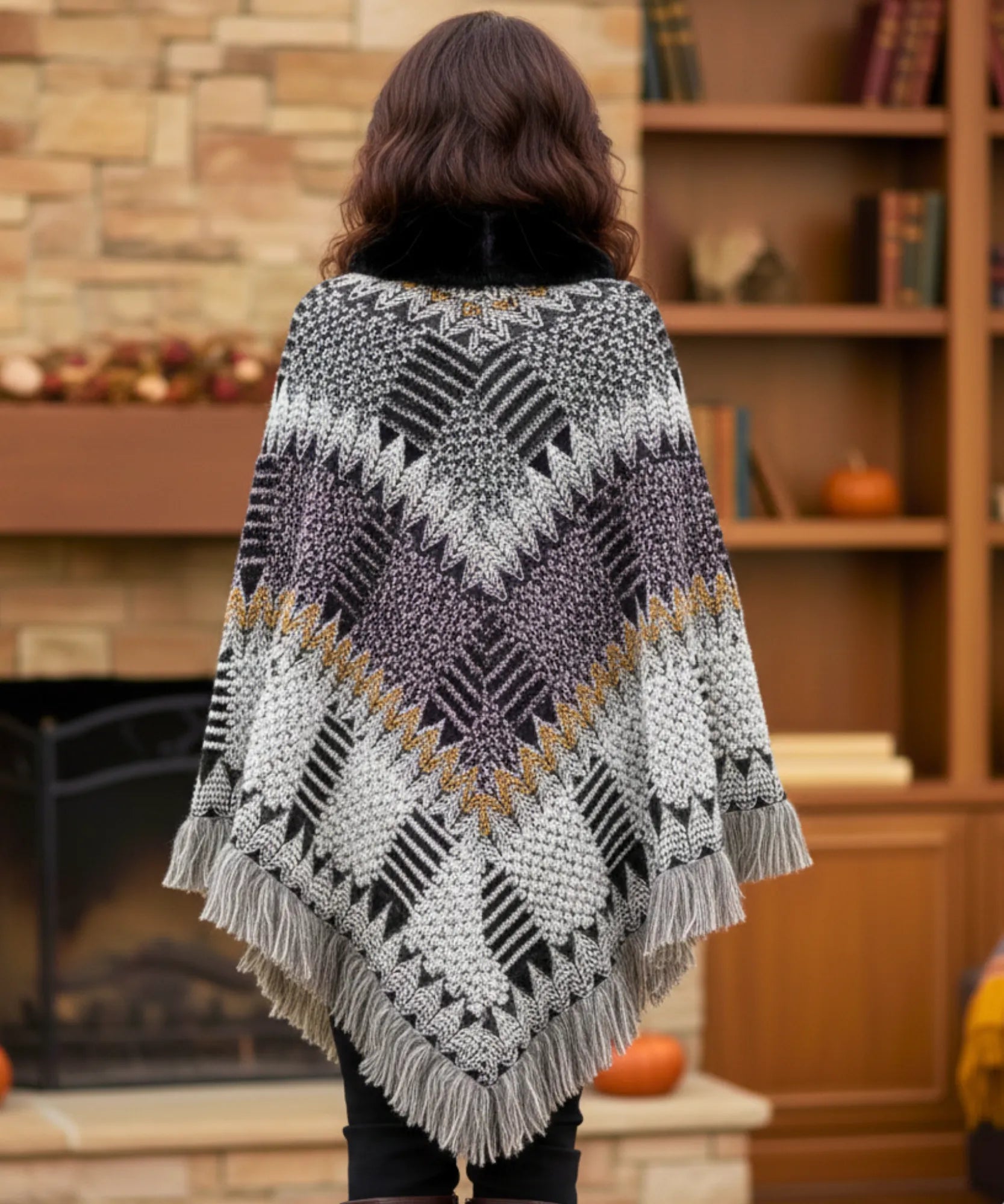 Women's boho poncho sweater in black and grey chunky knit with fur-trim collar, back view