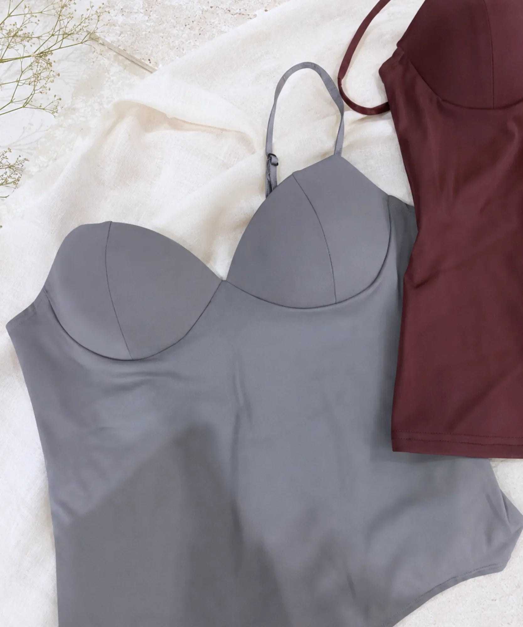 Flat lay of grey and burgundy bustier tops with structured cups