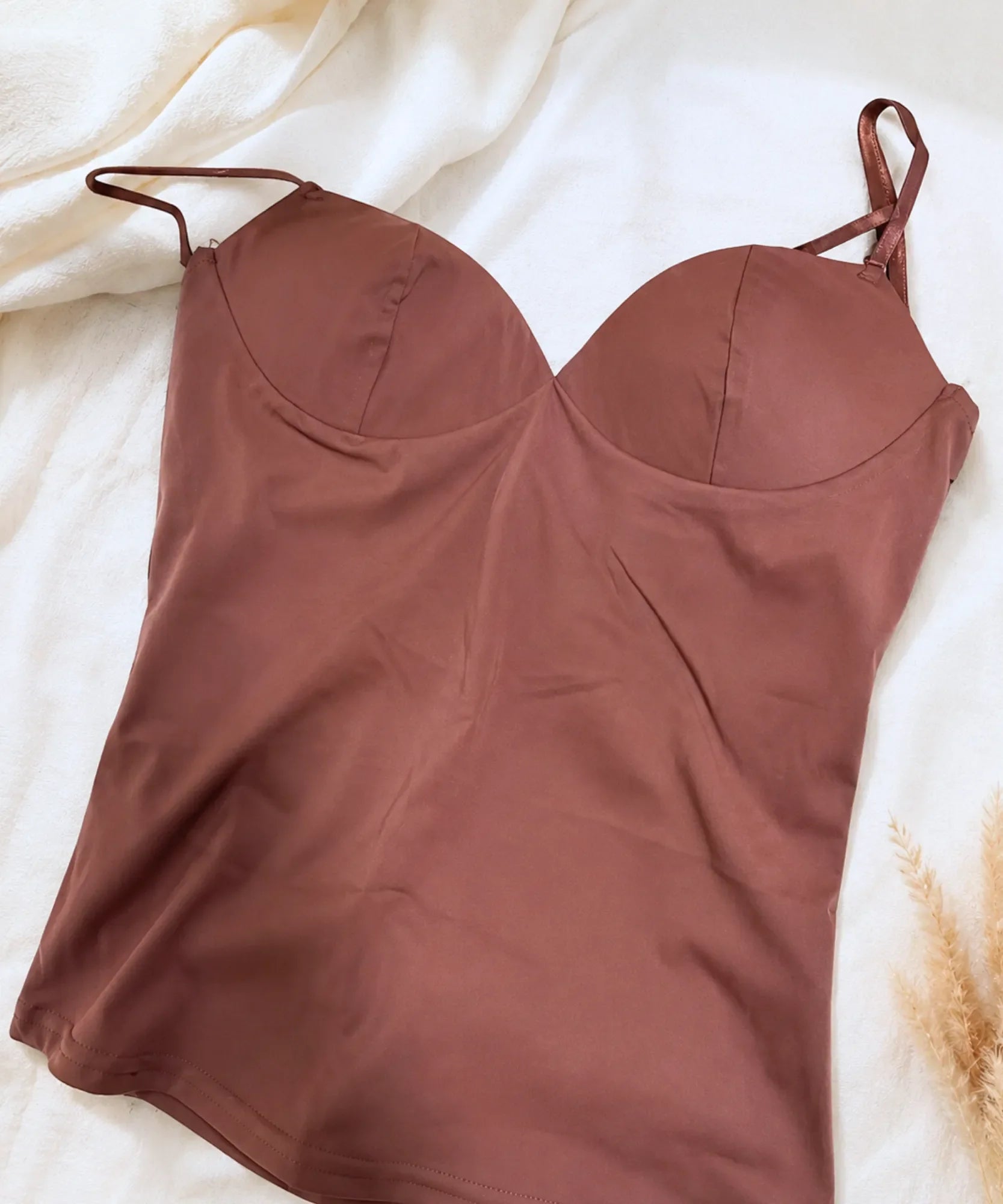 Flat lay of a chestnut brown bustier top with built in cups