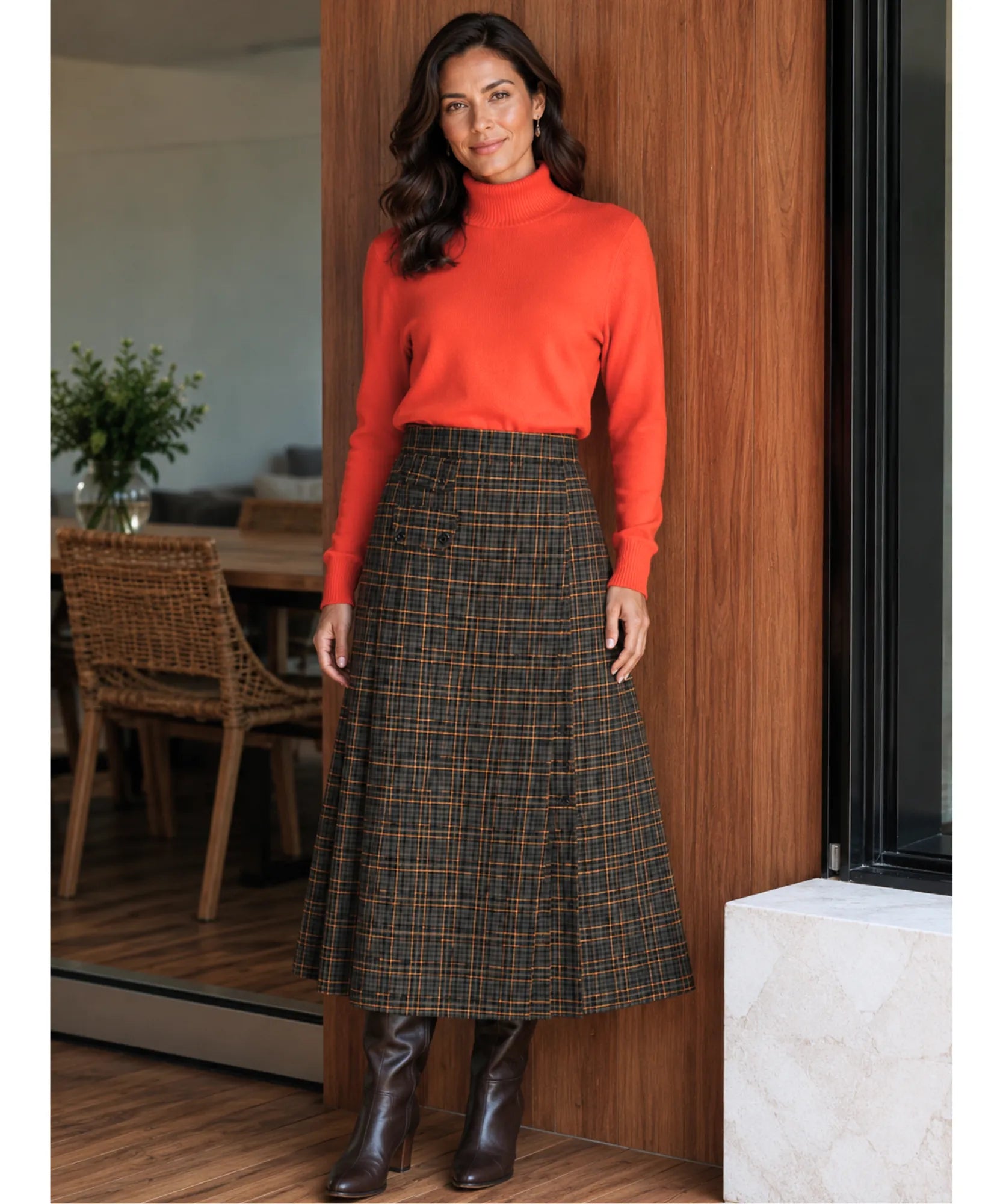 Women's brown plaid midi skirt styled with sweater and tall boots