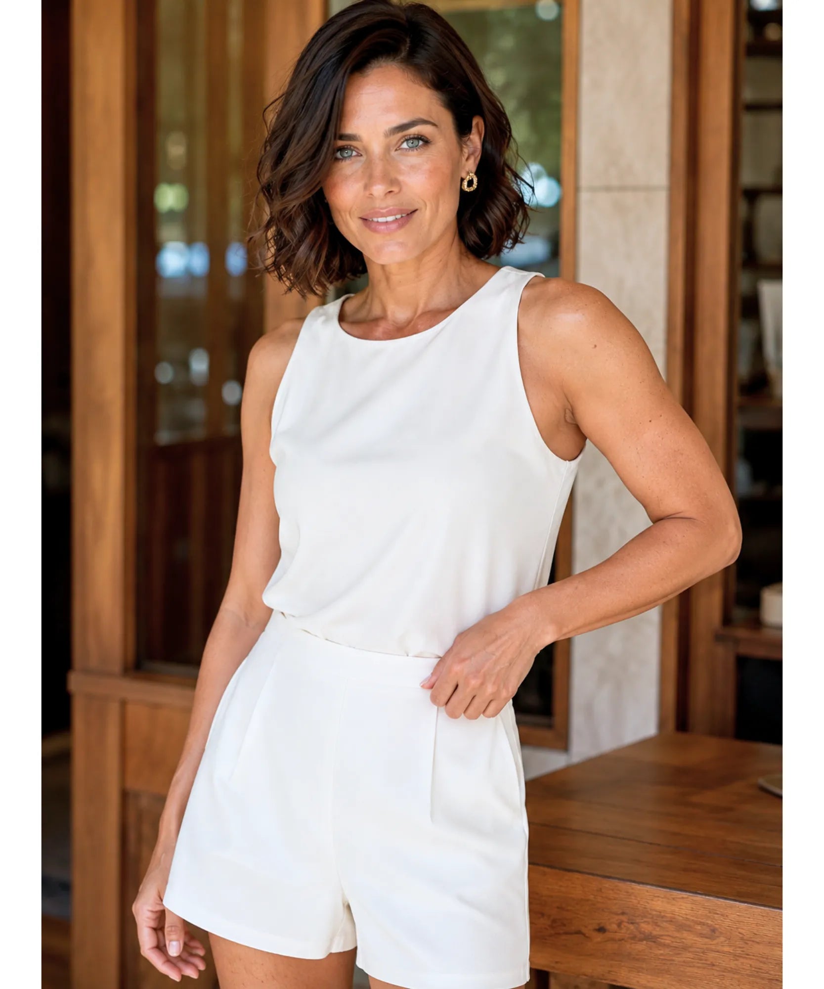 Women's white pleated shorts styled with a tank top