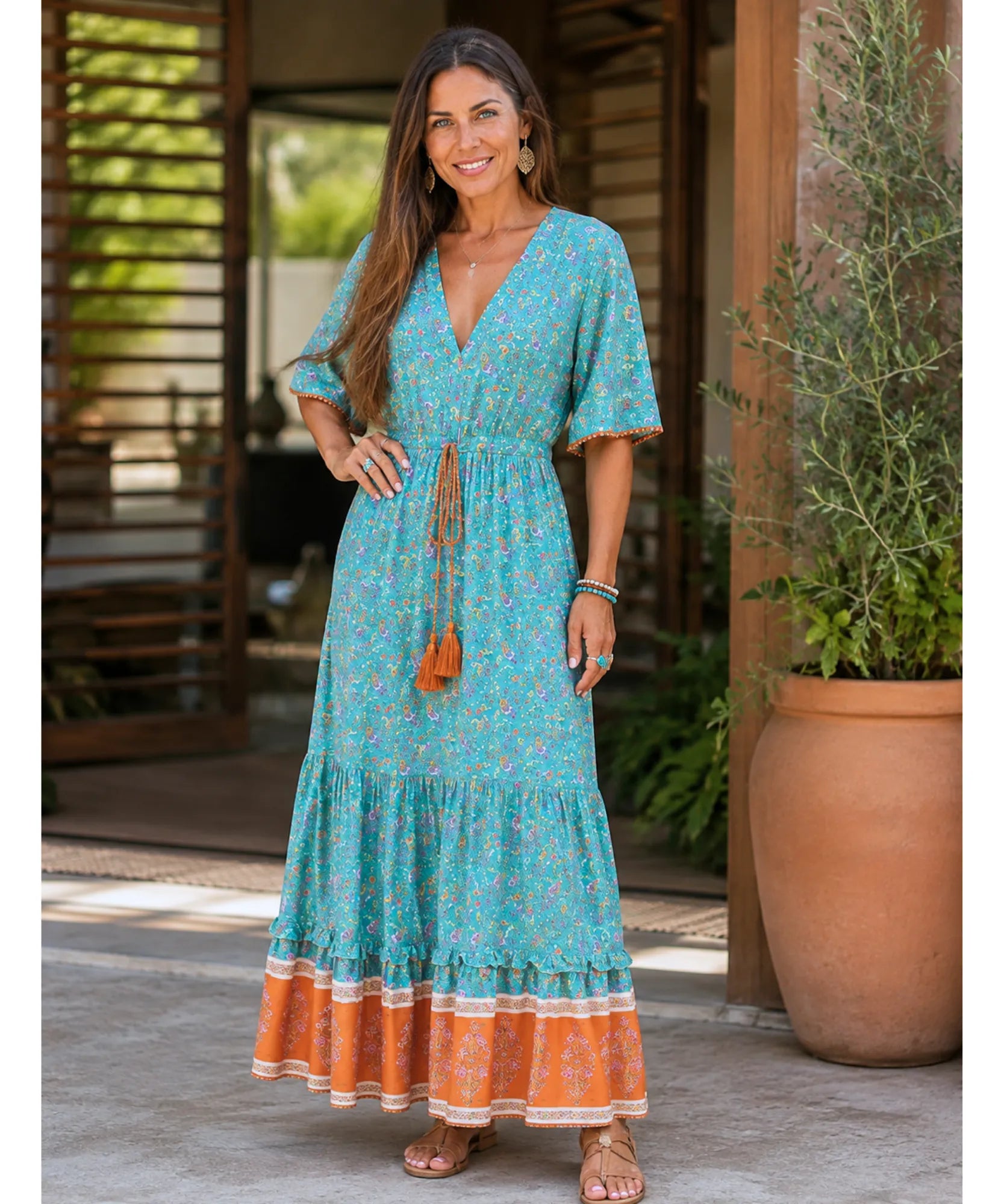 Turquoise boho maxi dress with V-neck and orange border, full-length front view