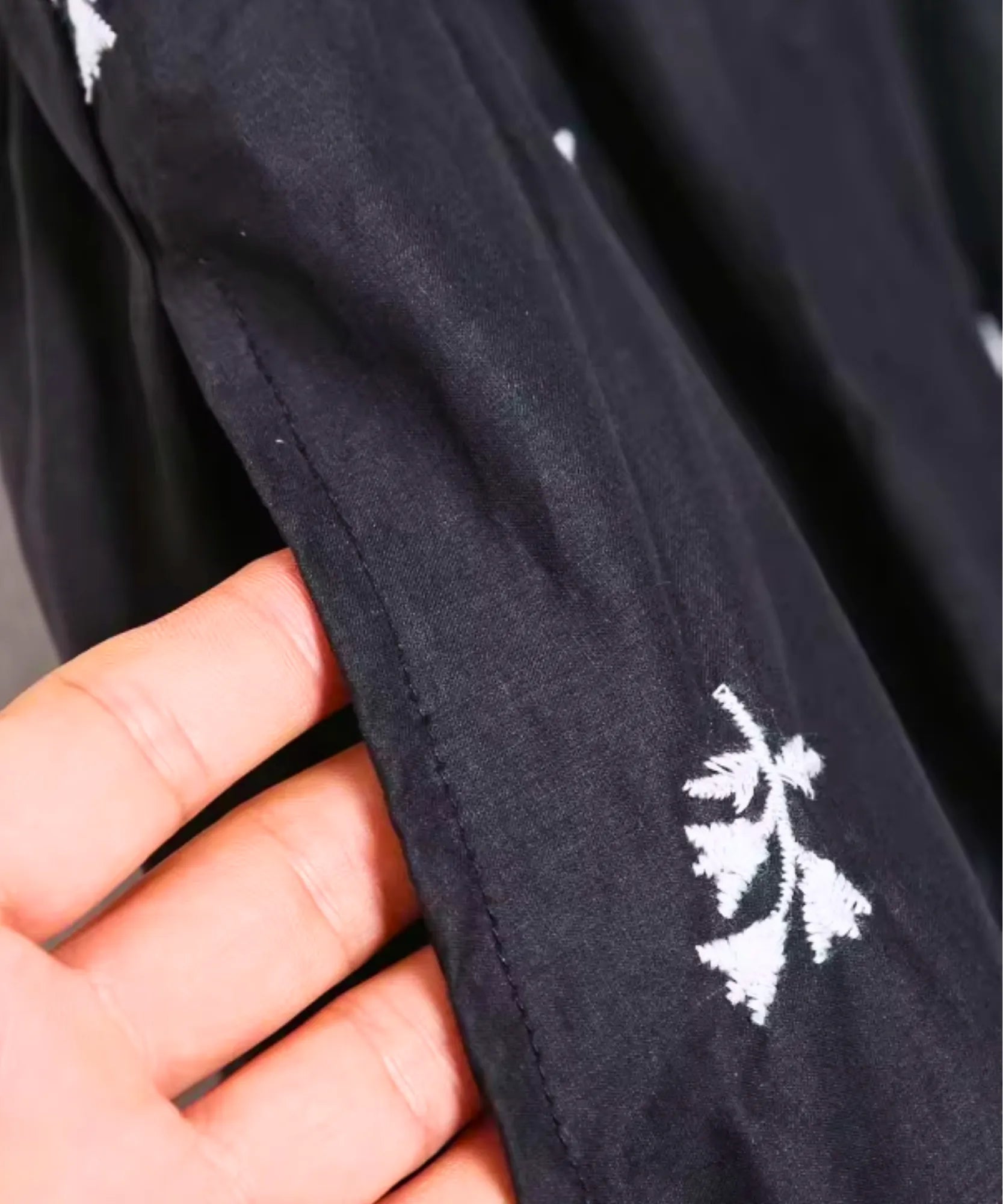 Women's Black Mini Dress with Floral Embroidery, close-up of the white floral embroidery